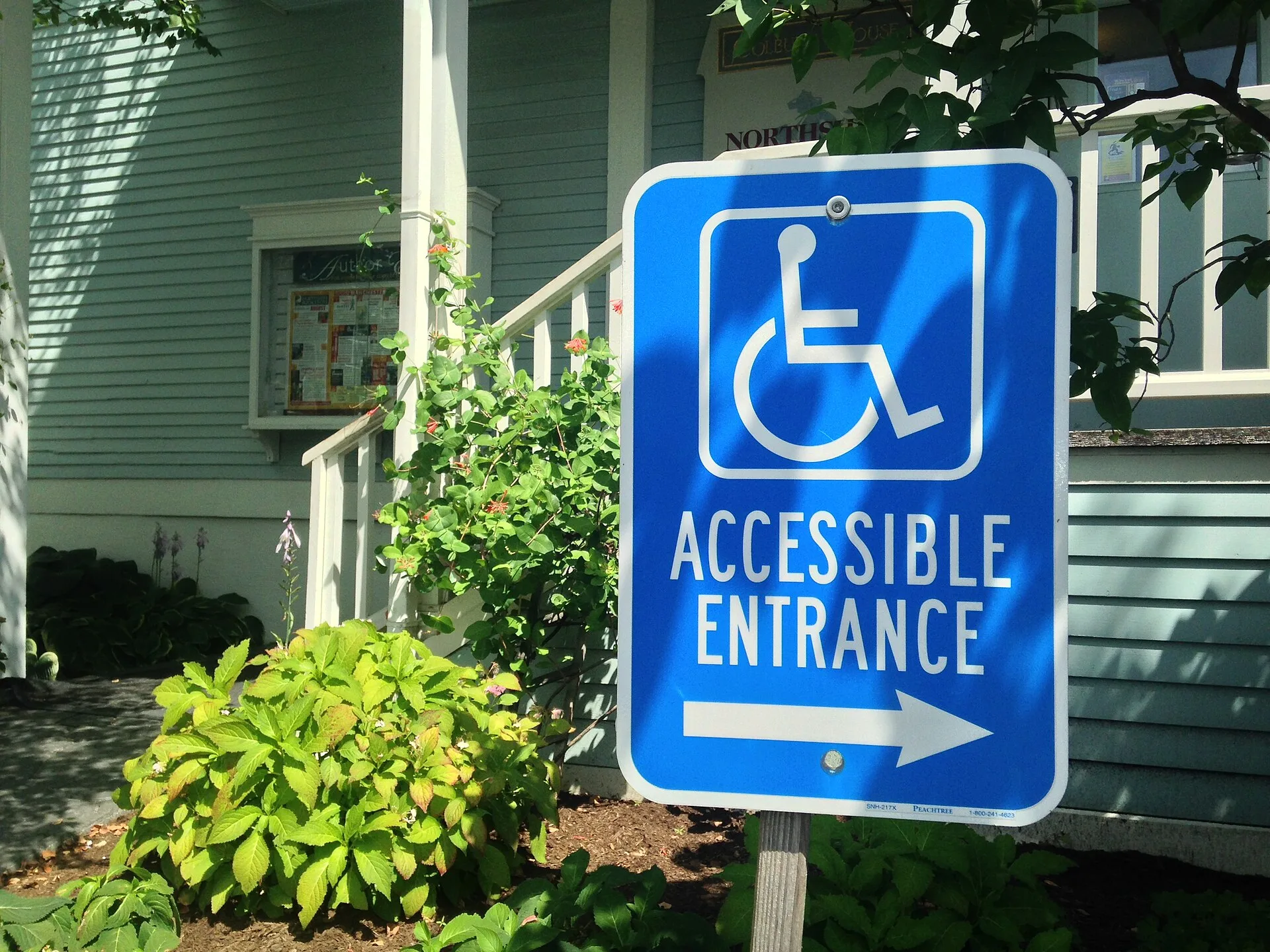 A sign indicating the location of the wheelchair ramp and entrance. Studio Itinerary Building Accessibility: A Planning Guide