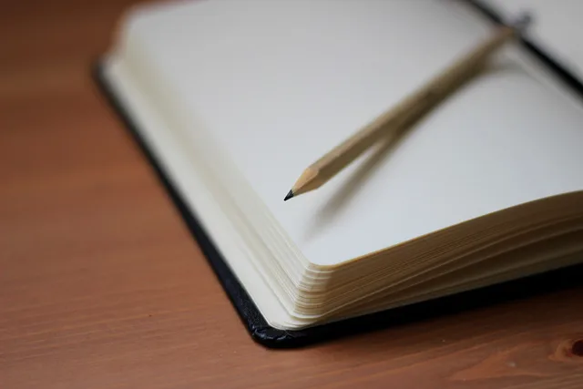 pencil, write, notebook, paper, desk, wooden, brown laptop, brown writing, brown desk. A writing retreat stay packing list built around protecting the manuscript